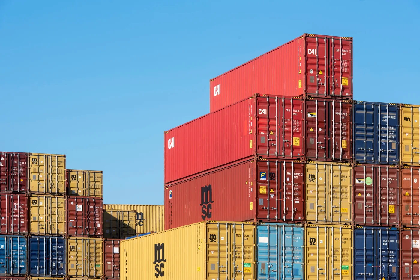 Stacked shipping containers showing regional freight disruption and fulfillment resilience in the GCC