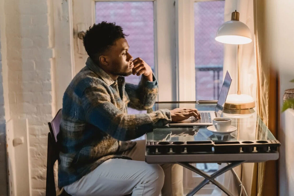 man typing on a laptop in his study room